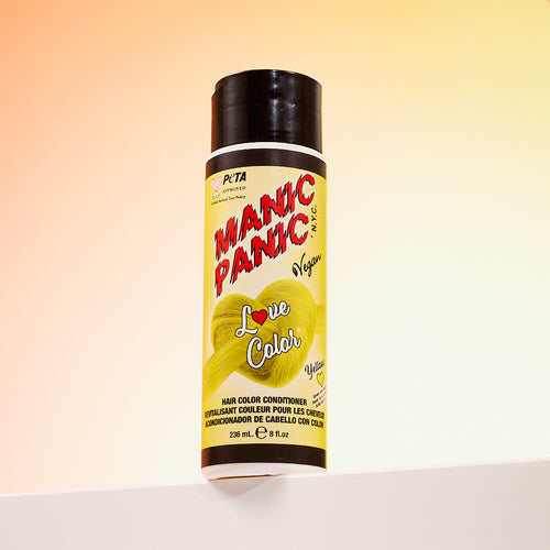 A bottle of Manic Panic® LOVE COLOR™ YELLOW HEART® conditioner. The packaging features red and blue graphics with text emphasizing the vegan formulation.