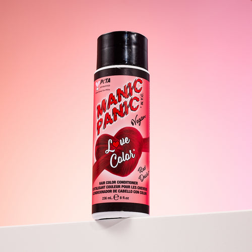 A bottle of Manic Panic® LOVE COLOR™ RED DESIRE® conditioner. The packaging features red and blue graphics with text emphasizing the vegan formulation.
