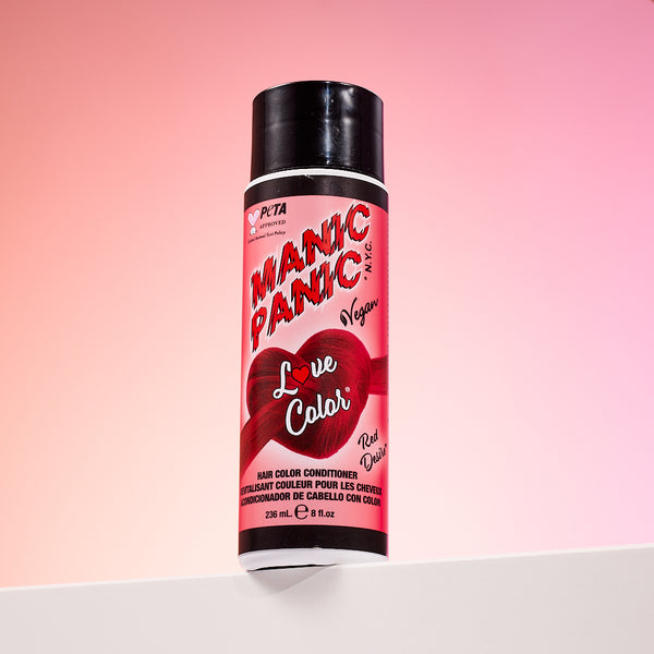 A bottle of Manic Panic® LOVE COLOR™ RED DESIRE® conditioner. The packaging features red and blue graphics with text emphasizing the vegan formulation.