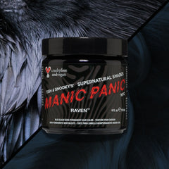 Jar of Manic Panic Raven™ Classic Cream semi-permanent hair dye in cool black, shown against a dark feather-textured background and a wavy black hair color swatch 