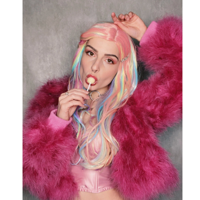 Person with colorful hair and pink fur coat against a gray background