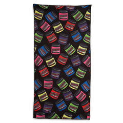 A vibrant Manic Panic beach towel with a black base and a multi-colored colored jar pattern.